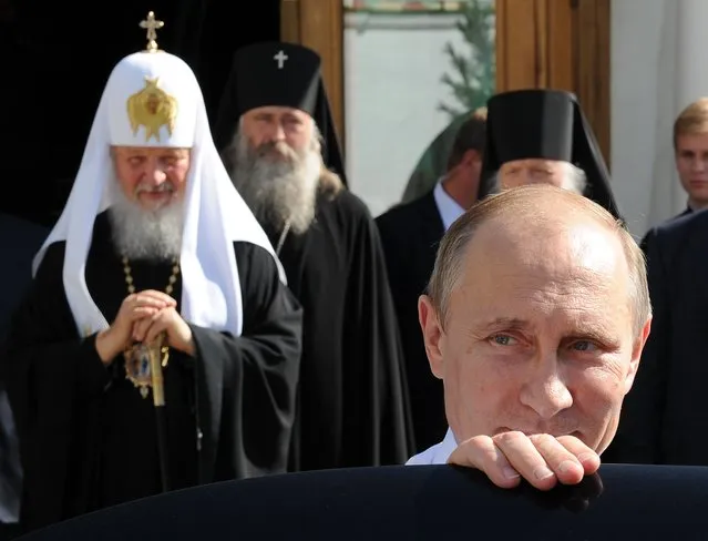Russian President Vladimir Putin, front, leaves after his meeting with Russian Orthodox Patriarch Kirill, left back, as he attends celebrations marking the 700th anniversary of St. Sergius of Radonezh in the Trinity St. Sergius monastery in Sergiyev Posad, northeast of Moscow, Friday, July 18, 2014. (Photo by Mikhail Klimentyev/AP Photo/RIA-Novosti/Presidential Press Service)