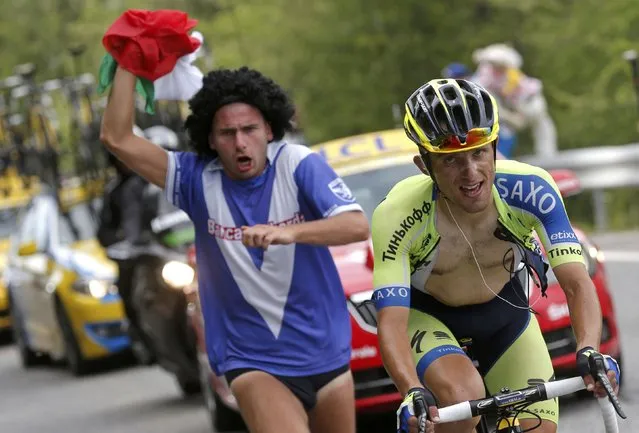 Tinkoff-Saxo team rider Ral Majka of Poland is chased by a supporter as he cycles to win the 177-km fourteenth stage of the Tour de France cycling race between Grenoble and Risoul, July 19, 2014. (Photo by Christian Hartmann/Reuters)