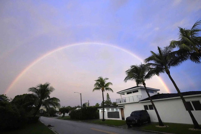 A rainbow appears in the skies between rain showers over Surfside, Fla., on Thursday, June 13, 2024. A tropical disturbance brought a rare flash flood emergency to much of southern Florida the day before. Floridians prepared to weather more heavy rainfall on Thursday and Friday. (Photo by Wilfredo Lee/AP Photo)