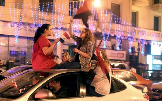 Girls wave national flags as they ride in a car in Tahrir square where people gather to celebrate the opening of an extention of the Suez Canal, in Cairo, Egypt, August 6, 2015. (Photo by Asmaa Waguih/Reuters)