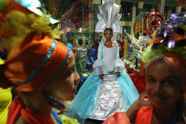 Young performers wear elaborate and colorful costumes as they prepare to dance and march in the annual Carnival parade along the Malecon seawall boulevard August 14, 2015 in Havana, Cuba. The origins of the Havana Carnival can be traced back to 1576 when freed slaves were given permission by the town council of Havana to participate in the procession of the Corpus Christi. (Photo by Chip Somodevilla/Getty Images)