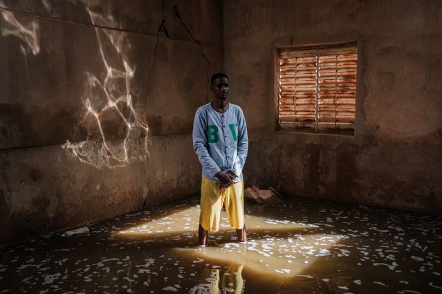 Teacher Suleyman Ba stands in a classroom of the Ecole de Diogel with water marks from flooding less then a week before and water still ankle deep in class rooms and waste deep in the court yard in Dioguel on October 22, 2024. Floods along the Senegal river have affected over 55,000 people after heavy rain in the Senegal River Basin leaving many villages underwater and over 1,000 hectares of farm land submerged. (Photo by Guy Peterson/AFP Photo)