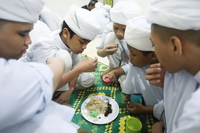 Koranic students break their fast during the holy fasting month of Ramadan at an Islamic boarding school in Kuala Lumpur, Malaysia, April 11, 2022. (Photo by Hasnoor Hussain/Reuters)