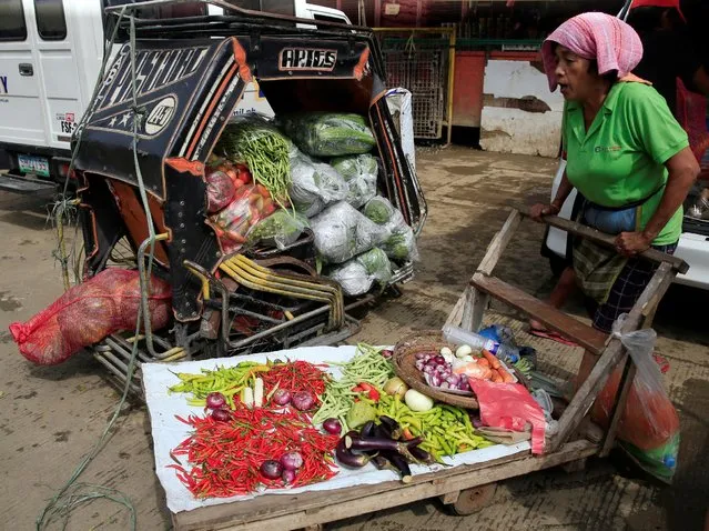A vendor pushes her cart filled with vegetables to sell at a wet market in Metro Manila, Philippines July 4, 2016. (Photo by Romeo Ranoco/Reuters)