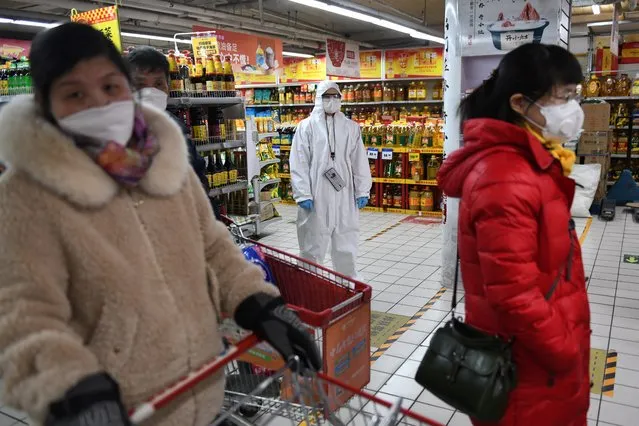 A worker wears protective clothing as a preventive measure against the COVID-19 coronavirus as she watches over customers in a supermarket in Beijing on March 3, 2020. The world has entered uncharted territory in its battle against the deadly coronavirus, the UN health agency warned, as new infections dropped dramatically in China on March 3 but surged abroad with the US death toll rising to six. The world has entered uncharted territory in its battle against the deadly coronavirus, the UN health agency warned, as new infections dropped dramatically in China on March 3 but surged abroad with the US death toll rising to six. (Photo by Greg Baker/AFP Photo)