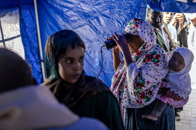 A voter carrying a baby on her back gets her biometrics registered before casting her vote at a polling station during the 2024 Somaliland presidential election in Hargeisa on November 13, 2024. Somaliland, a breakaway region of Somalia, holds a presidential election on November 13, 2024 at a time of diplomatic tensions in the Horn of Africa. (Photo by Luis Tato/AFP Photo)
