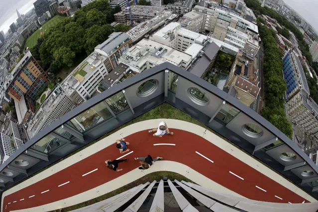 In this picture taken with a fish-eye lens, people who volunteered to pose for photographs in their running gear, run along a stretch of the new 150 meter rooftop running track, as seen from the roof terrace of the recently redeveloped 16-storey office tower of the White Collar Factory development in London, Tuesday, September 5, 2017. The new track is the highest one in London. (Photo by Matt Dunham/AP Photo)