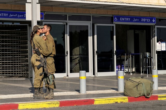 Israeli soldiers kiss by a train station, amid the ongoing conflict between Israel and the Palestinian Islamist group Hamas, in Ashkelon, southern Israel on October 16, 2023. (Photo by Ilan Assayag/Reuters)