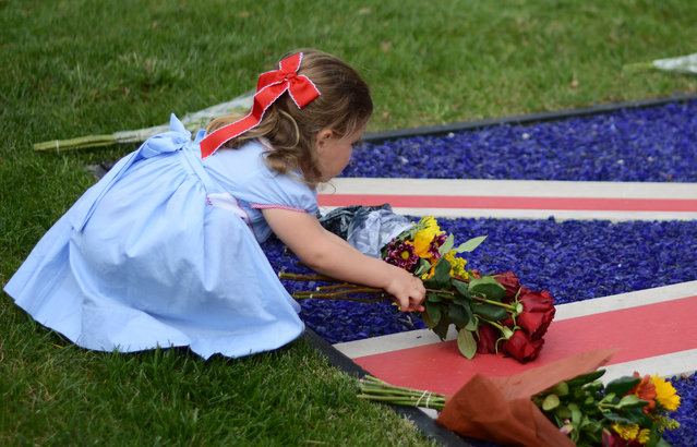 Three-year-old India Rogers leaves flowers at the British embassy in Washington, D.C, September 8, 2022, following the announcement of the death of Queen Elizabeth II. The queen died today at age 96 after 7 decades of a symbolic but stable leadership. (Photo by Astrid Riecken For The Washington Post)