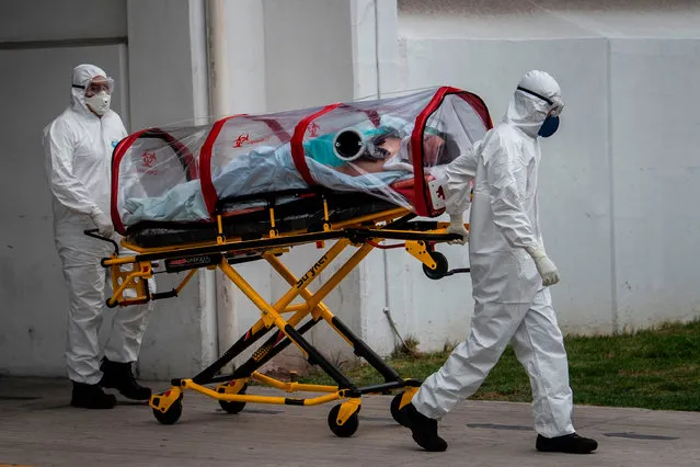Red Cross' paramedics carry a patient suspected of being infected with the novel coronavirus into the Traumatology Hospital of the Mexican Institute of Social Insurance (IMSS), in Mexico City, on May 20, 2020. (Photo by Pedro Pardo/AFP Photo)