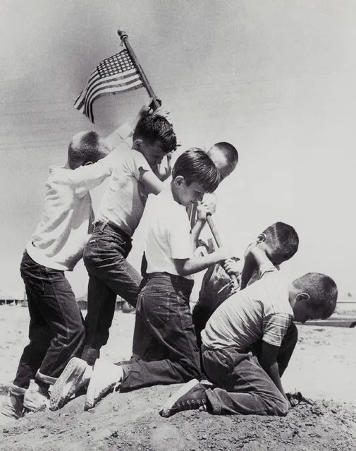 The combination of an imaginative photographer and six neighborhood kids raising the Flag Day colors over their vacant lot fort recreates the famed Iwo Jima flag raising scene of World War II, at Lakewood Plaza, near Long Beach, Calif., June 14, 1955. The junior size “Marines” are left to right: Mike McChargue, 11; Larry Hoshe 8; George Kayuck, 8; Mike Jones, 8; Dick Sandstrom, 8, and Casy Vose, 8. (Photo by AP Photo)
