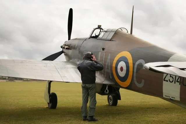 Pilot Dave Harvey checks a Hawker Hurricane Mk XIIa 5711 (G-HURI) fighter aircraft before performing an aerobatic display at the IWM Duxford on October 18, 2012 in Duxford, England. The aeroplane, similar to those that defended British shores during the Battle of Britain in World War II, is due to be auctioned by Bonhams in their sale of “Collectors' Motor Cars and Automobilia” at Mercedes-Benz World Brooklands on December 3, 2012. The plane was built in 1942 and joined the Royal Canadian Air Force the following year, where it remained for the duration of the war, it is expected to fetch up to 17 million GBP.  (Photo by Oli Scarff)