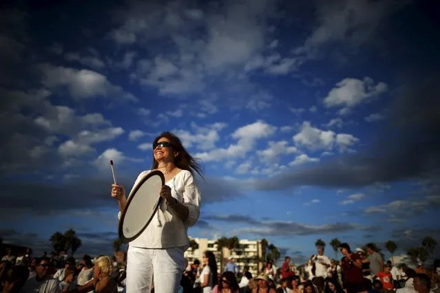 Rabbi Naomi Levy plays music at the Nashuva Spiritual Community Jewish New Year celebration on Venice Beach in Los Angeles, California, United States September 14, 2015. As Jews take part in the Tashlich prayer, a Rosh Hashanah ritual, bread crumbs are tossed into the waters to symbolically cast away sins. (Photo by Lucy Nicholson/Reuters)