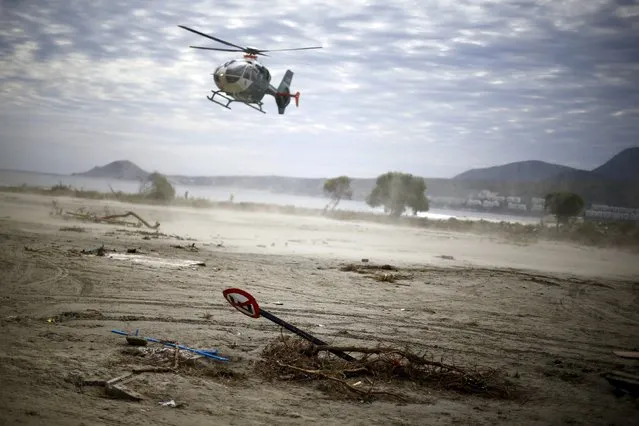 A helicopter takes off next to a damaged street after an earthquake hit areas of central Chile, in Tongoy town, next to Coquimbo city, north of Santiago, September 18, 2015. (Photo by Ivan Alvarado/Reuters)