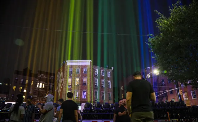 A rainbow light display illuminates the night sky in the West Village near The Stonewall Inn, birthplace of the gay rights movement, Saturday, June 27, 2020, in New York. The light installation was presented by Kind snack foods to mark what would have been the 50th anniversary of the NYC Pride March, which is canceled this year because of the coronavirus pandemic. (Photo by Bebeto Matthews/AP Photo)