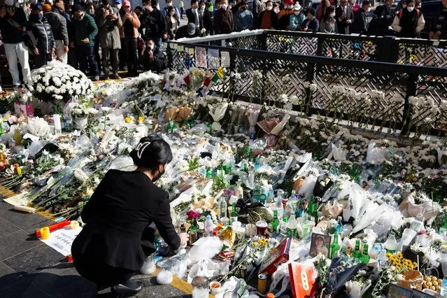 A woman lays flowers to pay tribute to victims of the Seoul Halloween stampede, in Seoul, South Korea, 02 November 2022. According to the National Fire Agency, at least 154 people were killed and 149 were injured in the stampede on 29 October as a large crowd came to celebrate Halloween. (Photo by Jeon Heon-Kyun/EPA/EFE/Rex Features/Shutterstock)