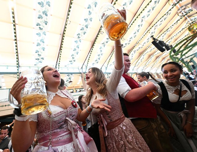 Visitors cheer and celebrate on the day of the official opening of the 189th Oktoberfest, the world's largest beer festival in Munich, Germany on September 21, 2024. (Photo by Angelika Warmuth/Reuters)