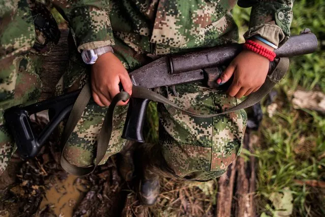A member of the “Omar Gomez” Western War Front of the National Liberation Army (ELN) guerrilla holds her gun in a camp on the banks of the San Juan River, Choco department, Colombia, on November 20, 2017. Colombia's landmark peace deal with Marxist FARC rebels was supposed to mean peace for all but it has made little difference to indigenous and Afro-Colombian minorities, Amnesty International said on November 22, 2017. Although the agreement between the Colombian government and the FARC was signed, armed conflict is still very much the reality for millions across the country, said Salil Shetty, Secretary General at Amnesty International. (Photo by Luis Robayo/AFP Photo)
