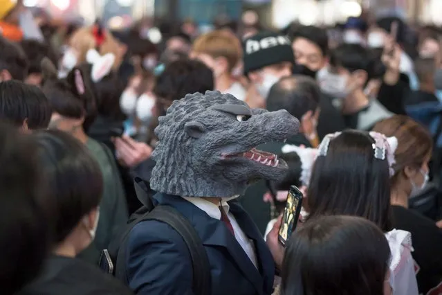 A man wearing a mask passes over Shibuya Crossing during Halloween on October 31, 2022 in Tokyo, Japan. (Photo by Tomohiro Ohsumi/Getty Images)