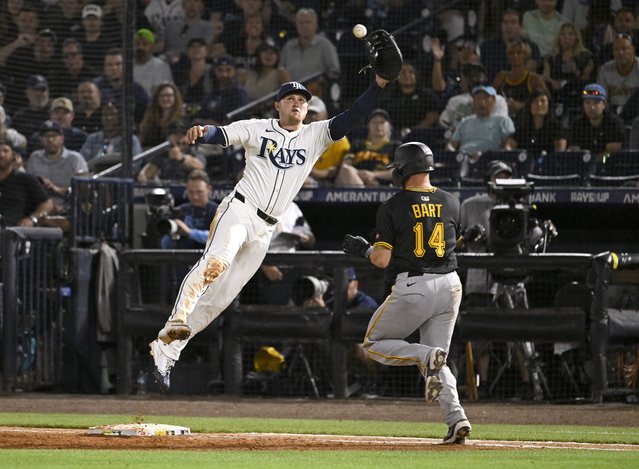 Tampa Bay Rays first base Curtis Mead jumps to catch the throw as Pittsburgh Pirates' Joey Bart (14) reaches first on an infield single during the sixth inning of a baseball game, Tuesday, April 1, 2025, in Tampa, Fla. (Photo by Jason Behnken/AP Photo)
