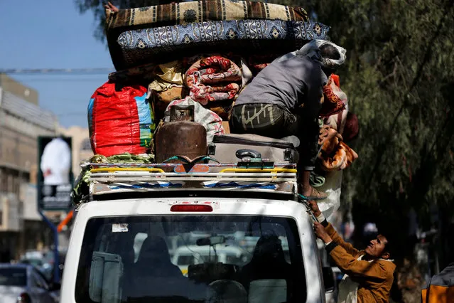 People load belongings on a van as they evacuate their house located on a street where Houthis have recently clashed with forces loyal to slain Yemeni former president Ali Abdullah Saleh in Sanaa, Yemen on December 6, 2017. (Photo by Khaled Abdullah/Reuters)