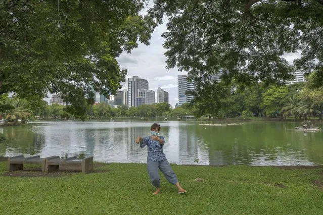 A woman wearing a face mask to help curb the spread of the coronavirus practices Tai Chi at Lumpini park in Bangkok, Thailand, Friday, June 26, 2020. Daily life in the capital resumes to normal as the government continues to ease restrictions related to running business and activities that were imposed weeks ago to combat the spread of COVID-19. Thailand reported no local transmissions of the coronavirus in the past 4 weeks. (Photo by Sakchai Lalit/AP Photo)