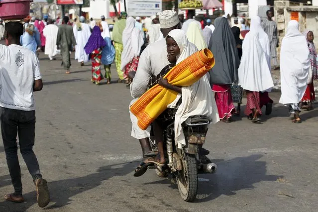 A man rides a motorcycle with his children after Islamic prayers marking the Eid al-Adha festival, outside Kofar Mata district mosque in the city of Kano, Nigeria September 24, 2015. (Photo by Akintunde Akinleye/Reuters)