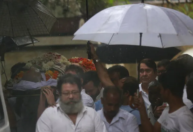Friends and relatives carry the body of Bollywood actor Shashi Kapoor during his funeral in Mumbai, India, Tuesday, December 5, 2017. Kapoor, a leading Bollywood actor and producer from the 1970s and '80s, died Monday after a long illness. He was 79. Actor Randhir Kapoor is seen on right. (Photo by Rafiq Maqbool/AP Photo)