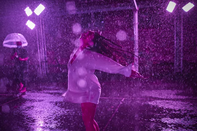 A woman dances at the “Purple Rain” installation at the Lycée Jacques-Decour on August 02, 2020 in Paris, France. Part of Festival Paris l'Eté, the installation by Pierre Ardouvin is a tribute to the song by Prince and allows visitors to role play while equipped with umbrellas and accompanied by the song. (Photo by Kiran Ridley/Getty Images)