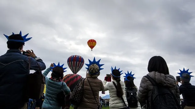 Attendees watch and take photographs as hundreds of hot air balloons take off during the 2015 Albuquerque International Balloon Fiesta in Albuquerque, New Mexico, October 4, 2015. (Photo by Lucas Jackson/Reuters)
