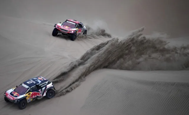 Peugeot's Spanish driver Carlos Sainz and co-driver Lucas Cruz (L) and Peugeot's French driver Cyril Despres and co-driver David Castera compete during the 2018 Dakar Rally Stage 2 in and around the Peruvian town of Pisco, on January 7, 2018. The 40th edition of the Dakar Rally will take competitors through Peru, Bolivia and Argentina until January 20. (Photo by Franck Fife/AFP Photo)
