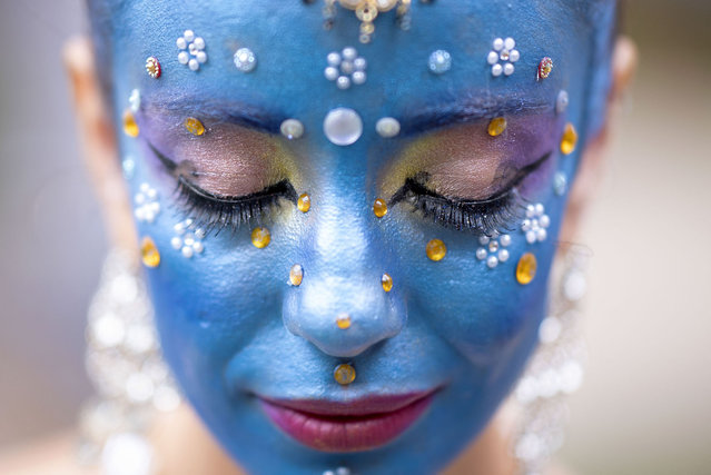 A member of the Pena de Pavao de Krishna traditional carnival group waits to perform in Belo Horizonte, Brazil, on February 11, 2024. The group, which celebrates Indian deities, paid homage to fighting women and masters of popular culture with the theme “Wombs of the Earth” (Ventres da Terra). (Photo by Douglas Magno/AFP Photo)