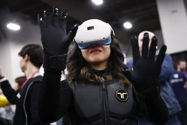 A person tries out bHaptic Inc.’s wireless haptic suit and gloves for VR/AR and gaming during the CES Unveiled Las Vegas at the 2023 International Consumer Electronics Show in Las Vegas, Nevada, USA, 03 January 2023. CES, the world's largest annual consumer technology trade show, taking place from 4-8 January 2022, is a place where industry manufacturers, advertisers and tech-minded consumers converge to get a taste of new innovations coming to the market each year. (Photo by Caroline Brehman/EPA/EFE)