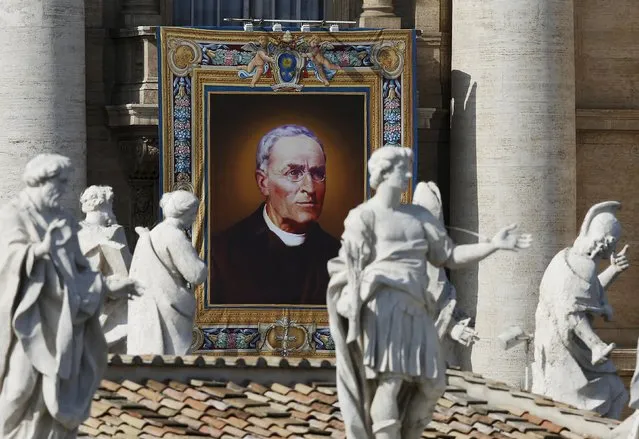 A tapestry showing Saint Vincenzo Grossi hangs from a balcony as Pope Francis leads the mass for a canonization in Saint Peter's Square at the Vatican October 18, 2015. Pope Francis will canonise husband and wife, Louis and Zelie Martin, known for being the parents of French Saint Therese of Lisieux. (Photo by Alessandro Bianchi/Reuters)