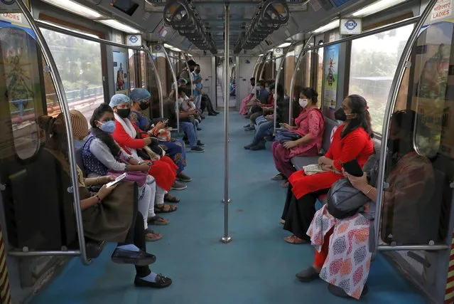 Passengers wearing protective masks travel inside a metro train on the first day of the restart of the metro operations, amidst the spread of the coronavirus disease (COVID-19), in Kolkata, India, September 14, 2020. (Photo by Rupak De Chowdhuri/Reuters)