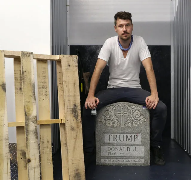 In this July 15, 2016 photo provided by Molly Krause Communications, artist Brian Andrew Whiteley sits on his sculpture, “The Trump Tombstone” bearing the name of Republican presidential candidate Donald Trump, in New York. The 500-pound slab was confiscated by the New York City Police Department after it appeared Central Park one night in the spring of 2016. The artist says the tombstone reflects “Trump's love of having his name on everything”. (Photo by Molly Krause/Molly Krause Communications via AP Photo)