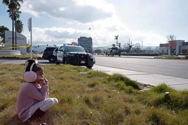 A young girl watches as police use armored vehicles to surround a white cargo van, believed by law enforcement to be connected to the Monterey Park mass shooting suspect according to an ABC affiliate, at a parking lot in Torrance, California on January 22, 2023. (Photo by Zaydee Sanchez/Reuters)