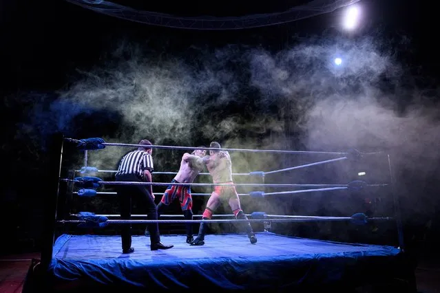 Professional wrestler Colt Miles (R) fights his opponent Dynamo H-block in a bout during an evening of wrestling entertainment presented by promoter “Megaslam Wrestling” in a circus big top in Sheffield, northern England on October 12, 2020. Prior to the coronavirus pandemic Megaslam Wrestling was Europe's most prolific wrestling show, typically staging over 300 events a year across the British Isles. (Photo by Oli Scarff/AFP Photo)
