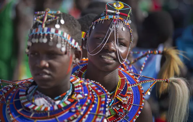 Young Maasai women arrive to support the young warriors from their village at the annual Maasai Olympics in the Sidai Oleng Wildlife Sanctuary near to Mt Kilimanjaro, in southern Kenya Saturday, December 13, 2014. (Photo by Ben Curtis/AP Photo)
