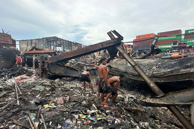 Men look for items which they can salvage from the remains of a building after a fire gutted a poor community last weekend leaving hundreds homeless in Manila, Philippines on Monday, September 15, 2025. (Photo by Joeal Calupitan/AP Photo)