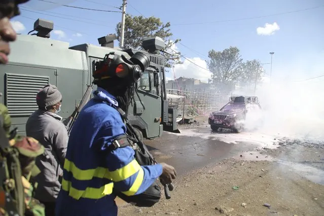 Police use tear gas and water jet spray on the opposition convoy on the outskirts of Nairobi, Thursday, March 30, 2023. (Photo by Patrick Ngugi/AP Photo)