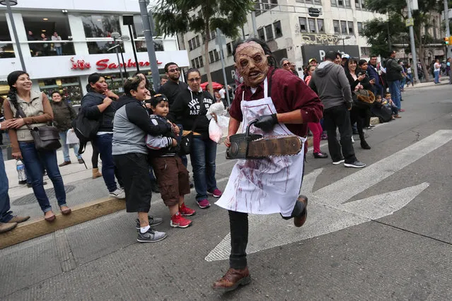 A man dressed as zombie runs as he participates in a Zombie Walk procession in Mexico City, Mexico, October 22, 2016. (Photo by Edgard Garrido/Reuters)