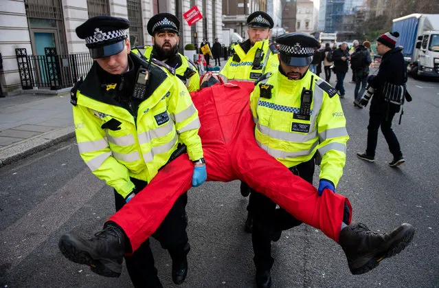 Greenpeace activists are arrested and cut out of chains whilst attempting to blockade the BP headquarters with solar panels, boards and activists locking themselves to oil drums on February 5, 2020 in London, England. Greenpeace started the blockade early in the morning ahead of the first day of work for the newly appointed BP CEO Bernard Looney. (Photo by Chris J. Ratcliffe/Greenpeace via Getty Images)