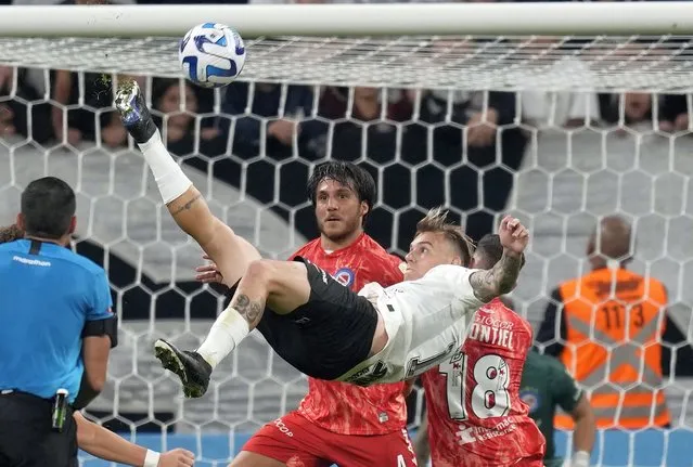 Roger Guedes of Brazil's Corinthians makes a bicycle kick as Kevin Mac Allister of Argentina's Argentinos Juniors, center, and teammate Santiago Montiel, right, look on during a Copa Libertadores group E soccer match at the Corinthians Arena in Sao Paulo, Brazil, Wednesday, April 19, 2023. (Photo by Andre Penner/AP Photo)