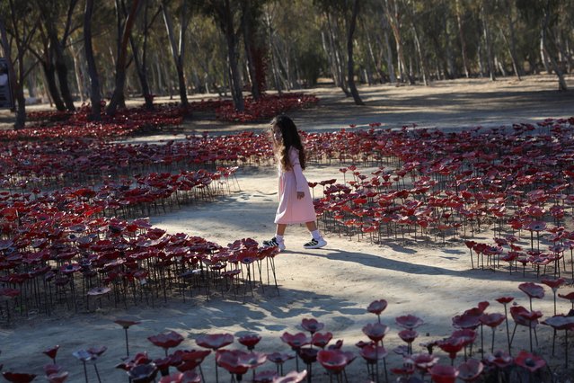 A girl walks through an installation of flowers at the site of the Nova festival where partygoers were killed and kidnapped, on the two-year anniversary of the deadly October 7, 2023 attack on Israel by Hamas from Gaza, in Reim, southern Israel, on October 7, 2025. (Photo by Itay Cohen/Reuters)