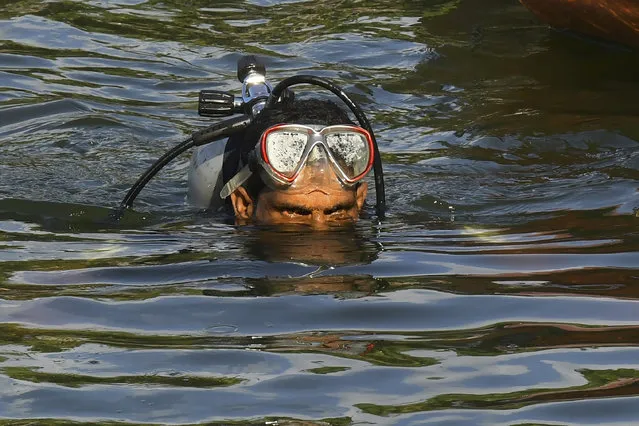 A diver searches a river after a tourist boat capsized Sunday night in Malappuram, Kerala, India, Monday, May 8, 2023. More than a dozen were killed. A double-decker boat carrying more than 30 passengers capsized Sunday night off a beach in southern India, and more than 22 people including children died, officials said. (Photo by P.P. Afthab/AP Photo)
