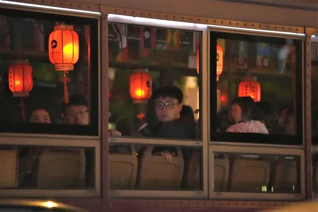 Tourists sit in a special bus decorated with red lanterns during a night tour in Beijing, Friday, May 5, 2023. (Photo by Ng Han Guan/AP Photo)