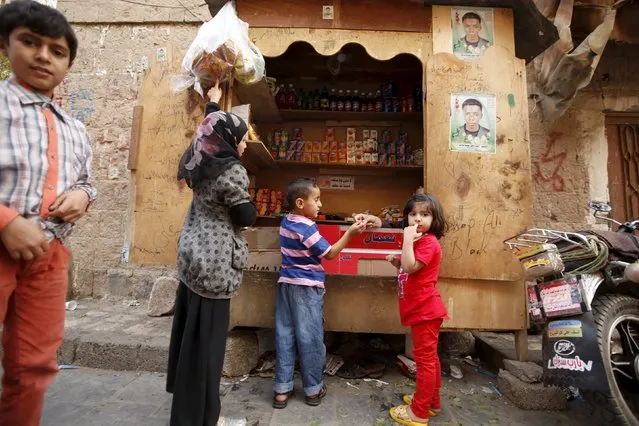Children buy candies from a street stall at the old quarter of Yemen's capital Sanaa November 27, 2015. (Photo by Khaled Abdullah/Reuters)