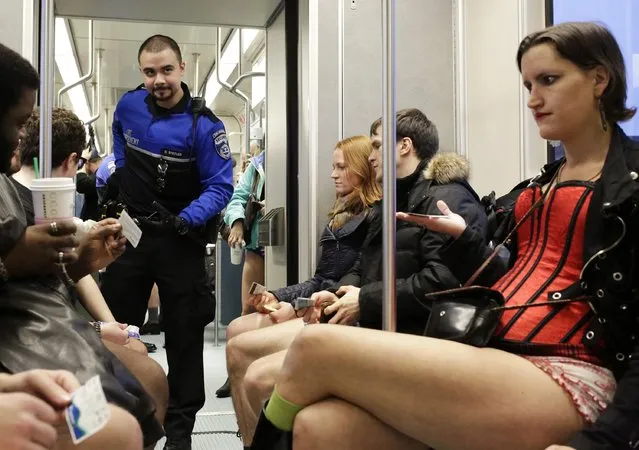 Transit security (L) checks riders' fares as people participate in the annual No Pants Light Rail Ride organized by the Emerald City Improv group in Seattle, Washington January 11, 2015. (Photo by Jason Redmond/Reuters)