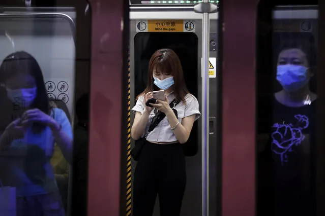 Commuters wearing face masks to protect against the new coronavirus ride in a subway train in Beijing, Wednesday, July 29, 2020. China reported more than 100 new cases of COVID-19 on Wednesday as the country continues to battle an outbreak in Xinjiang. (Photo by Andy Wong/AP Photo)